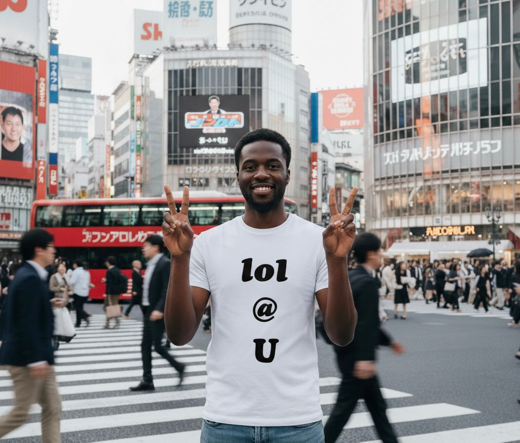 Person wearing a white t-shirt with 'lol @ u' text in a busy urban street with tall buildings and people.